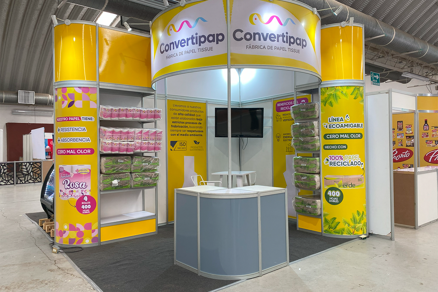 Stand de diseño circular para la marca Convertipap, destacando sus gráficos y productos.