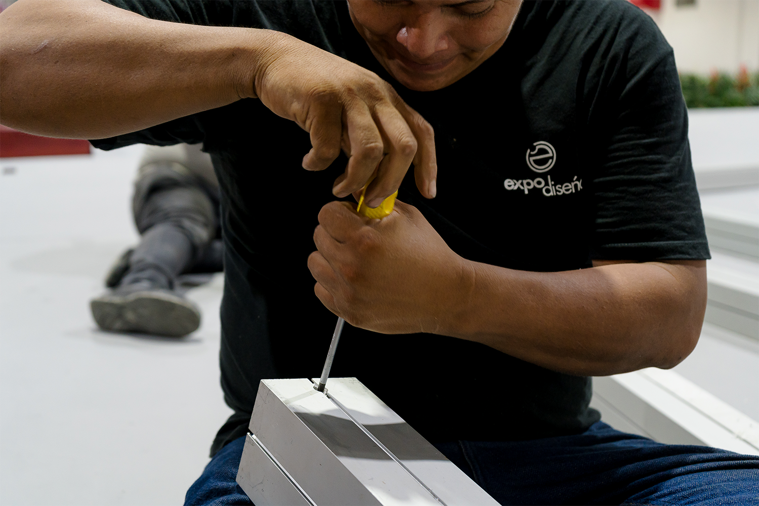 Técnico de Expodiseño durante el montaje de la escenografía, mostrando el trabajo detrás de cámaras.